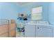 Bright laundry area with washer, dryer, utility sink, and storage shelf, perfect for household tasks at 1324 Eckles Dr, Tampa, FL 33612