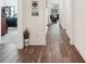 Hallway with wood-look floors, white trim and walls, and view into living room at 13355 Palmerston Rd, Riverview, FL 33579