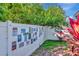 Backyard fence with greenery and colorful plants, decorated with artistic signs and decorative items at 1505 Trailwater St, Ruskin, FL 33570