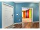 Foyer view of hardwood flooring, white front door, and an open doorway view of a multi-colored room at 1505 Trailwater St, Ruskin, FL 33570