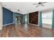 Open living room with hardwood floors, brick accent wall, and sliding glass doors to the screened patio at 1505 Trailwater St, Ruskin, FL 33570