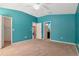 Spacious main bedroom featuring neutral carpeting, turquoise walls, and multiple doorways to other rooms at 1505 Trailwater St, Ruskin, FL 33570