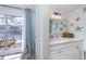 Bathroom featuring a large window, access to a waterfront balcony, vanity with a white countertop, and decorative starfish at 159 Medallion Blvd # H, Madeira Beach, FL 33708