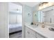 Bathroom leads to bedroom, features white vanity, and an elegant mirror at 159 Medallion Blvd # H, Madeira Beach, FL 33708