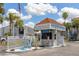 Charming Yacht Club Condos entrance with a guard house, palm trees, and tropical landscaping at 159 Medallion Blvd # H, Madeira Beach, FL 33708