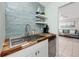 Contemporary kitchen featuring stainless sink, butcher block countertops, and stylish tiled backsplash at 159 Medallion Blvd # H, Madeira Beach, FL 33708