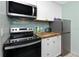 Well-equipped kitchen with stainless steel appliances, white cabinetry, and butcher block counters at 159 Medallion Blvd # H, Madeira Beach, FL 33708
