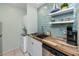 Efficient kitchen setup with in-unit washer/dryer, stainless steel sink, and tiled backsplash at 159 Medallion Blvd # H, Madeira Beach, FL 33708