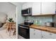 Well-equipped kitchen with modern appliances, wooden countertops, and stylish backsplash at 159 Medallion Blvd # H, Madeira Beach, FL 33708