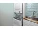 Convenient in-unit laundry area featuring stacked washer and dryer, with adjacent sink at 159 Medallion Blvd # H, Madeira Beach, FL 33708