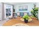 Bright living room featuring a cozy blue sofa, water view, and charming nautical décor at 159 Medallion Blvd # H, Madeira Beach, FL 33708