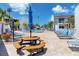 Relaxing pool area with chaise lounges, picnic tables, umbrellas, and tropical landscaping at 159 Medallion Blvd # H, Madeira Beach, FL 33708