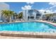 Large outdoor pool with clear blue water, community seating and resort-style landscaping at 159 Medallion Blvd # H, Madeira Beach, FL 33708