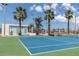 Community tennis court with palm trees, a tennis net, and a service area at 159 Medallion Blvd # H, Madeira Beach, FL 33708