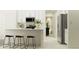 Modern kitchen featuring white cabinets, stainless steel appliances, and bar stool seating at 17512 Shirewood Way, Land O Lakes, FL 34638