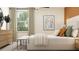 Well-lit bedroom with a queen bed, throw pillows, and a wooden dresser with decorations at 17518 Shirewood Way, Land O Lakes, FL 34638