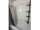 Clean bathroom featuring a tub with shower and shelving for toiletries at 1799 N Highland Ave # 32, Clearwater, FL 33755