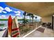 Condo balcony featuring surfboards, seating, and a view of the river and boat docks on a sunny day at 18201 Gulf Blvd # 201, Redington Shores, FL 33708