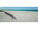 Beautiful beach view of long row of benches on a sandy beach along the water's edge offers a serene spot for relaxation at 18201 Gulf Blvd # 201, Redington Shores, FL 33708