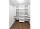 Spacious walk-in closet featuring wood-style floors and custom shelving for organization at 18201 Gulf Blvd # 201, Redington Shores, FL 33708