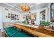 Dining room featuring a wooden table, a green bench, modern lighting, and an open bar to the kitchen at 18201 Gulf Blvd # 201, Redington Shores, FL 33708