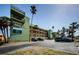Exterior view of the condominium building with ample parking surrounded by mature palm trees, creating a tropical ambiance at 18201 Gulf Blvd # 201, Redington Shores, FL 33708
