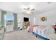 Comfortable bedroom features a ceiling fan, TV, mirror, and plenty of natural light at 22223 Storybook Cabin Way, Land O Lakes, FL 34637