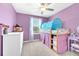 Bright bedroom featuring a playful lofted bed, soft purple walls, and a ceiling fan at 22223 Storybook Cabin Way, Land O Lakes, FL 34637