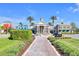 Inviting community clubhouse featuring a fountain, palm trees, and beautifully landscaped walkway on a sunny day at 22223 Storybook Cabin Way, Land O Lakes, FL 34637
