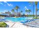 Stunning resort-style community pool with many lounge chairs and palm trees under a sunny blue sky at 22223 Storybook Cabin Way, Land O Lakes, FL 34637