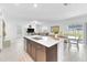 Open-concept living area and kitchen with a large island, a dining table, and sliding glass doors at 22223 Storybook Cabin Way, Land O Lakes, FL 34637