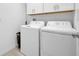 White laundry room with washer and dryer, plus overhead storage at 22223 Storybook Cabin Way, Land O Lakes, FL 34637