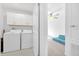 Laundry room features white washer and dryer next to a doorway to a bedroom at 22223 Storybook Cabin Way, Land O Lakes, FL 34637