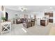 Spacious living room featuring a large leather sectional, tile floors, and an open layout at 22223 Storybook Cabin Way, Land O Lakes, FL 34637