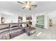 Bright and airy living room with a large leather sofa and seamless flow into the open kitchen at 22223 Storybook Cabin Way, Land O Lakes, FL 34637