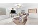 Cozy living area featuring a comfortable leather sectional, a large TV, and bright natural light at 22223 Storybook Cabin Way, Land O Lakes, FL 34637