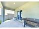 Covered patio featuring a grill and sliding glass doors leading to the interior of the home at 22223 Storybook Cabin Way, Land O Lakes, FL 34637