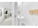 A stylish powder room featuring a pedestal sink, a mirror, and a glimpse of the living area at 22223 Storybook Cabin Way, Land O Lakes, FL 34637
