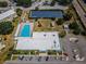Aerial view of the community pool, clubhouse, solar panels, and parking lot surrounded by landscaping at 2255 Philippine Dr # 21, Clearwater, FL 33763