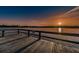 Sunset view of a community dock with protective railings over the tranquil water at 2255 Philippine Dr # 21, Clearwater, FL 33763