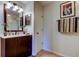 Bathroom featuring dark brown vanity, a large mirror with lighting, and a coordinated towel rack at 2323 Feather Sound Dr # F101, Clearwater, FL 33762