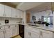 Modern kitchen with white cabinets, stainless steel sink, and open view to the dining and living area at 2323 Feather Sound Dr # F101, Clearwater, FL 33762