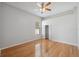 Sunlit bedroom with hardwood floors, ceiling fan, and a window with blinds at 2816 Pankaw Ln, Valrico, FL 33596