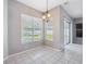 Bright dining area featuring tile floors, a chandelier, and sliding door to backyard at 2816 Pankaw Ln, Valrico, FL 33596