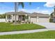 Well-maintained single-story home featuring a lush green lawn, palm trees, and a spacious three-car garage at 2816 Pankaw Ln, Valrico, FL 33596