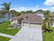 Charming home featuring a well-manicured lawn, mature palm trees, and a three-car garage at 2816 Pankaw Ln, Valrico, FL 33596