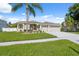 Well-maintained home with a lush green lawn, freshly painted driveway, and tropical palm tree landscaping at 2816 Pankaw Ln, Valrico, FL 33596