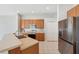 Kitchen with stainless steel refrigerator and oven plus wood cabinets and tiled floor at 2816 Pankaw Ln, Valrico, FL 33596