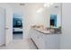 Bright bathroom featuring double vanity with granite countertop and view to bedroom at 3047 Adams Cross Dr, Zephyrhills, FL 33540
