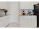 Well-lit kitchen featuring white cabinets, granite countertops, and modern appliances at 3047 Adams Cross Dr, Zephyrhills, FL 33540